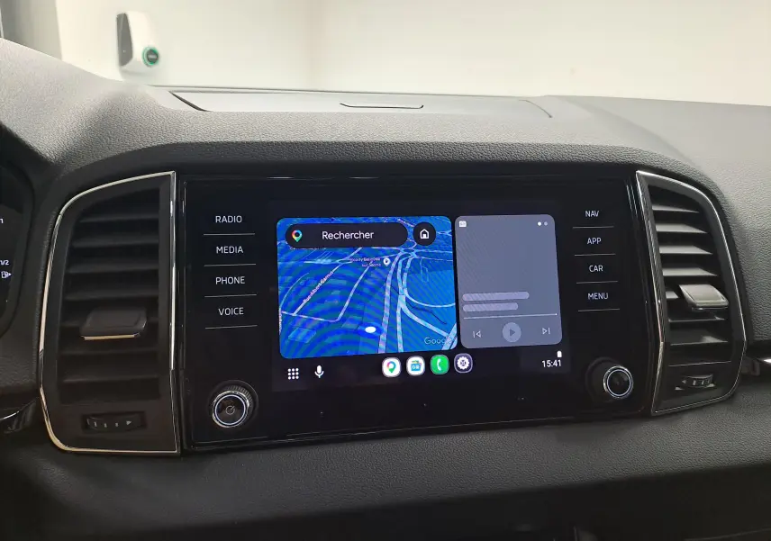 Vue rapprochée de l’écran tactile central du Skoda Karoq noir Magic Nacré avec navigation et commandes tactiles visibles.