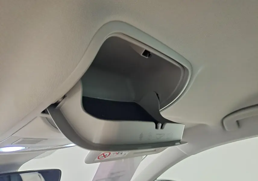 Vue intérieure en gros plan du rangement lunettes ouvert sur le plafond du Skoda Karoq noir Magic Nacré 2023.