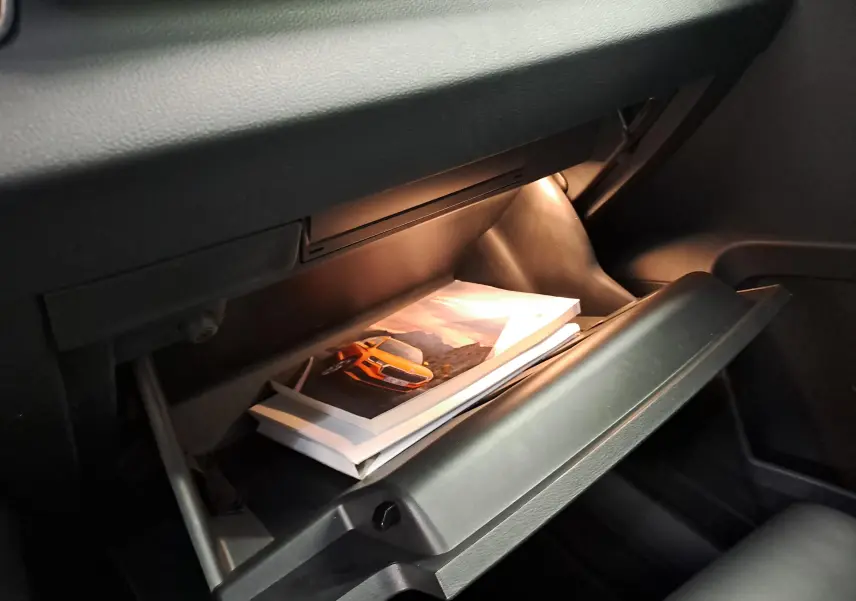 Gant de boîte à gants ouvert du Skoda Karoq 2023, éclairage intérieur et documents visibles, intérieur noir.