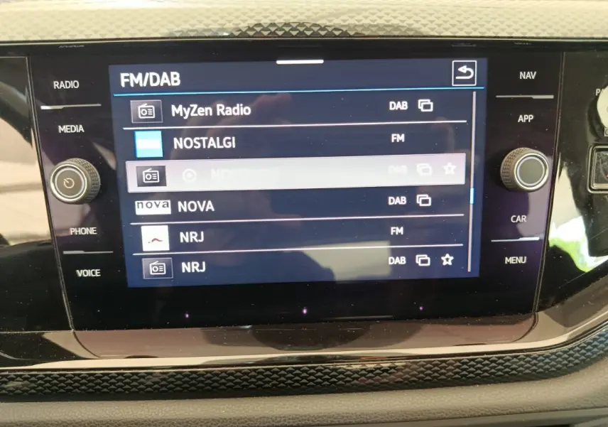 Écran tactile central de la Volkswagen Polo 2023 affichant les stations radio FM/DAB, vue intérieure rapprochée.