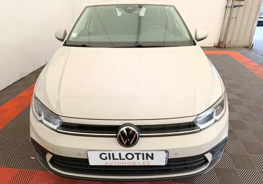 Vue avant d'une Volkswagen Polo gris clair 2023 avec calandre noire et logo VW centré.