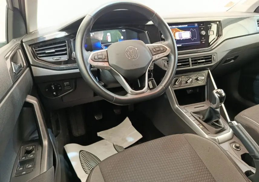Vue intérieure frontale du volant cuir et alu d'une Volkswagen Polo 2023 avec tableau de bord digital et écran tactile.