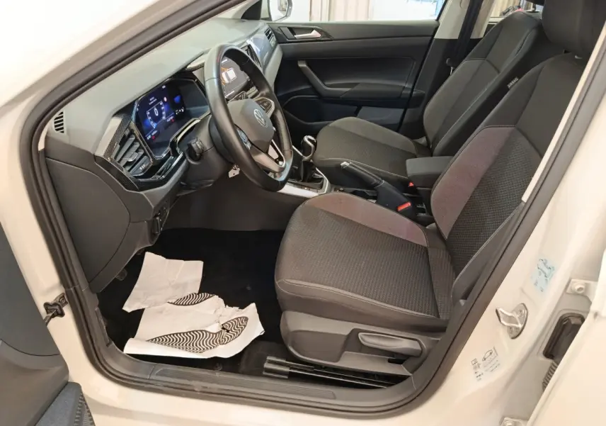 Vue intérieure côté conducteur de la Volkswagen Polo gris clair 2023, avec volant multifonctions et tableau de bord numérique.