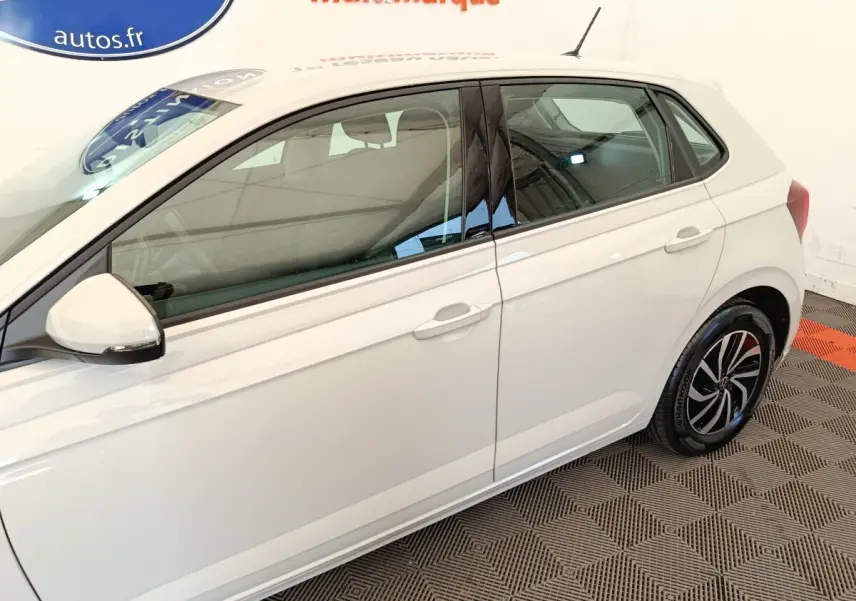 Vue latérale droite d'une Volkswagen Polo gris clair avec jantes alliage et rétroviseurs blancs.