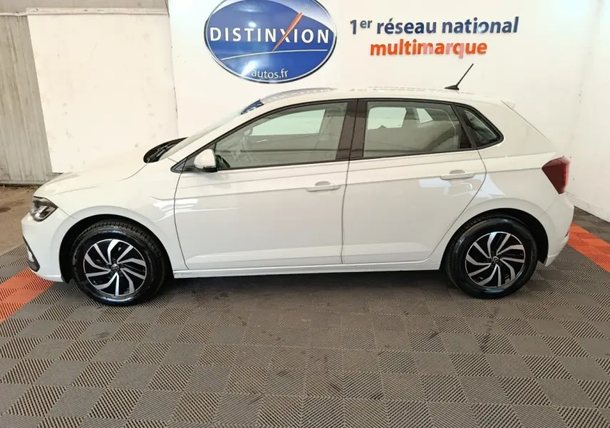 Vue de profil côté gauche d'une Volkswagen Polo 2023 gris clair avec jantes alliage noires et blanches.