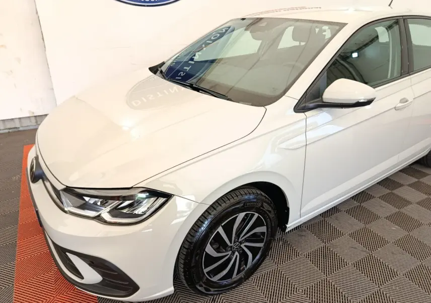 Vue 3/4 avant droit d'une Volkswagen Polo blanche avec jantes alliage et rétroviseurs blancs.