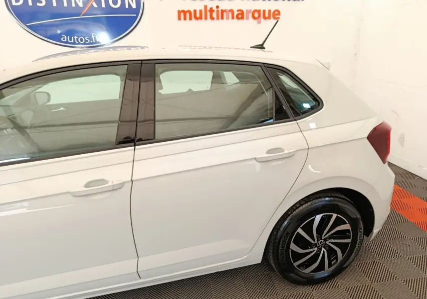 Vue côté droit arrière d'une Volkswagen Polo gris clair avec jantes alliage et vitres teintées.