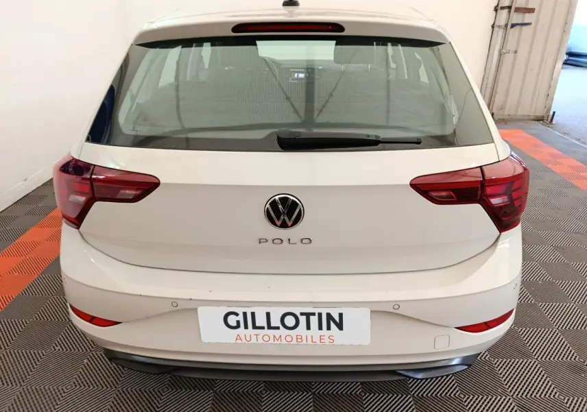 Vue arrière d'une Volkswagen Polo gris clair 2023 avec feux arrière rouges et logo VW centré.