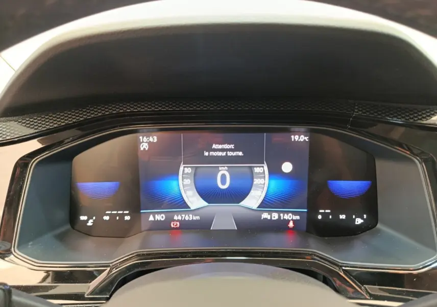Vue rapprochée du tableau de bord numérique de la Volkswagen Polo 2023 affichant la vitesse à 0 km/h et diverses informations.