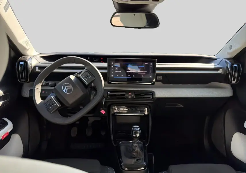 Vue intérieure avant de la Citroën C3 1.2 turbo 100 essence 2025, volant multifonction et écran tactile central.