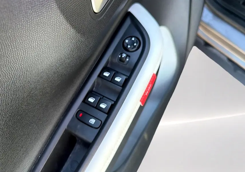 Gros plan sur la commande des vitres électriques côté conducteur de la Citroën C3 2025, garniture intérieure gris clair.