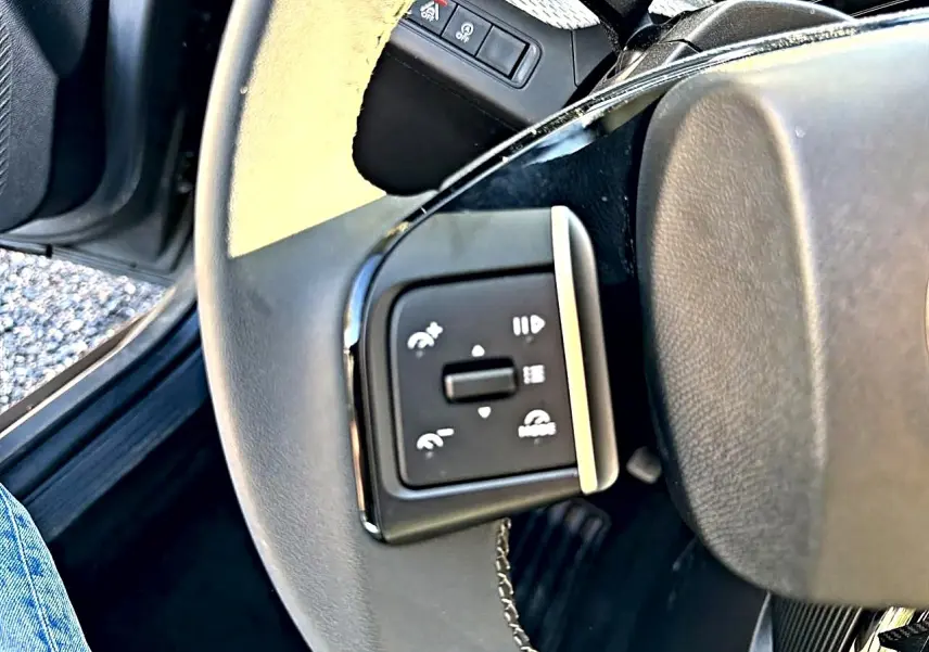 Gros plan sur les commandes audio et téléphone au volant d’une Citroën C3 gris mercure, intérieur côté conducteur.