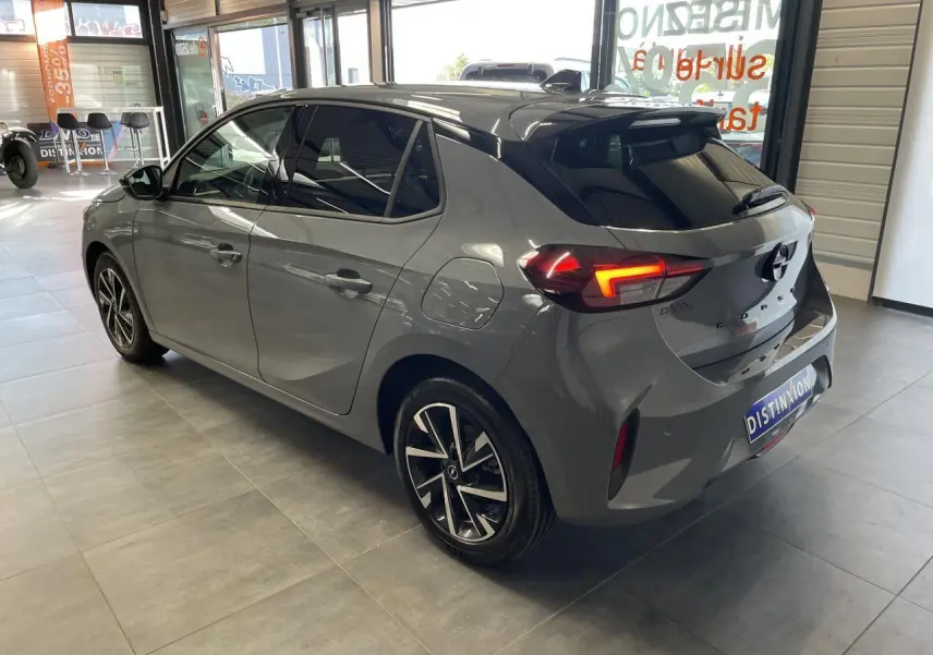 Vue 3/4 arrière droite d'une Opel Corsa gris Grafik avec feux LED et jantes alliage diamantées en showroom.