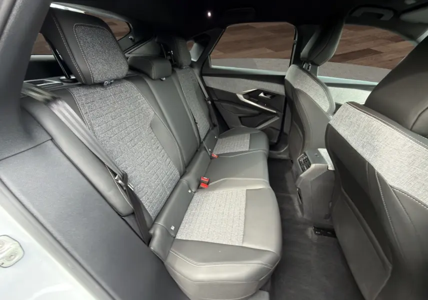 Vue intérieure arrière côté gauche du Peugeot 3008 2025 blanc, sièges bi-matière cuir et tissu gris clair.