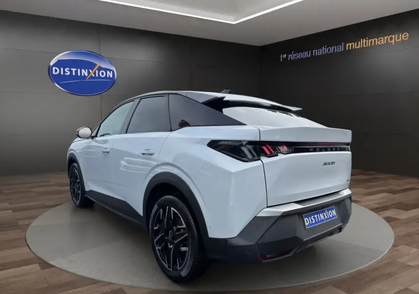 Vue 3/4 arrière droite du Peugeot 3008 blanc avec feux arrière LED et jantes noires en showroom.
