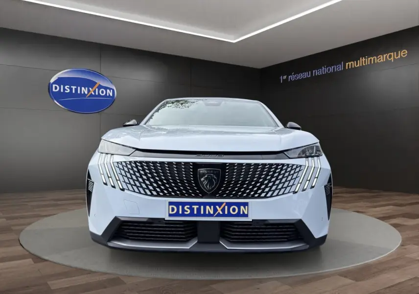 Vue frontale du Peugeot 3008 blanc 2025 avec calandre noire à motif géométrique et phares LED distinctifs.
