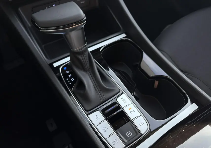 Gros plan sur la console centrale du Hyundai Tucson 2025 avec levier de vitesses cuir et commandes de conduite.