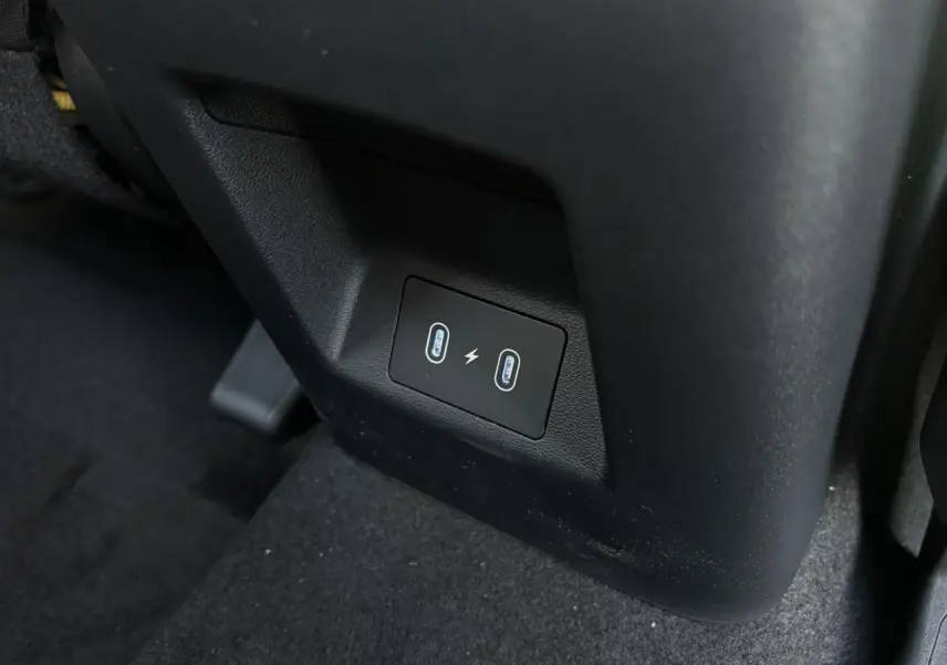 Prise USB double en bas du siège avant dans l'habitacle noir du Hyundai Tucson Cypress Green 2025.