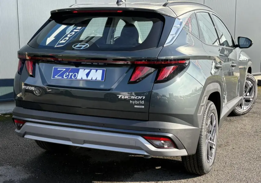 Vue 3/4 arrière droite du Hyundai Tucson Cypress Green avec feux arrière LED et logo hybride visible.
