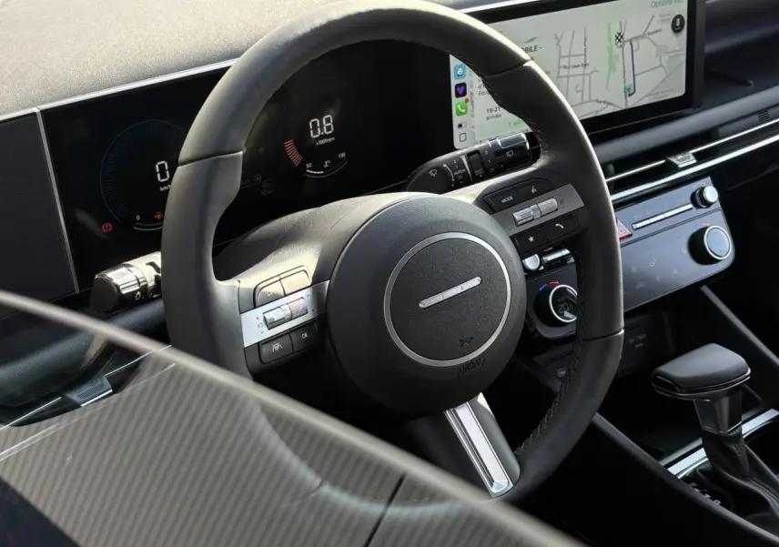 Vue rapprochée du volant cuir et du tableau de bord numérique du Hyundai Tucson 2025, avec écran tactile et commandes intégrées.
