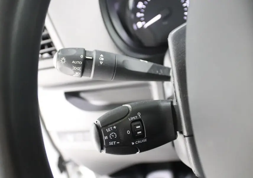 Gros plan sur les commandes de régulateur de vitesse et des feux au volant d'un Citroën Jumpy blanc de 2019.