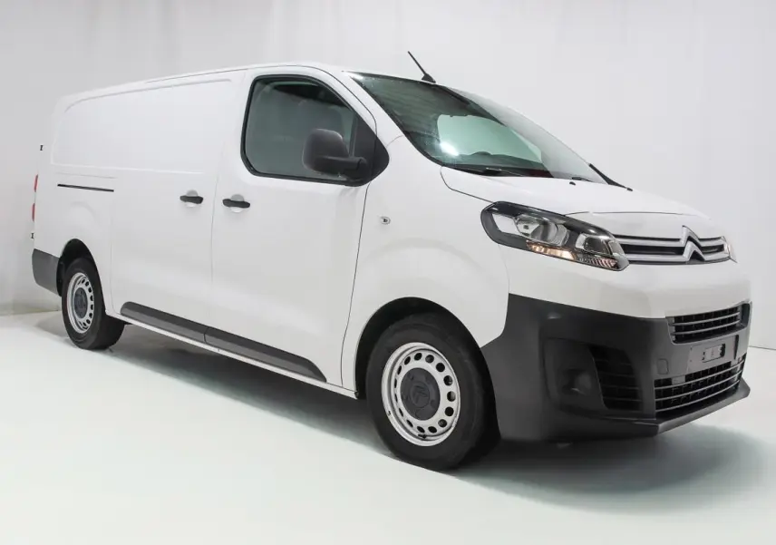 Vue 3/4 avant droite d'un Citroën Jumpy blanc version Fourgon XL avec attelage et kit bois visible.