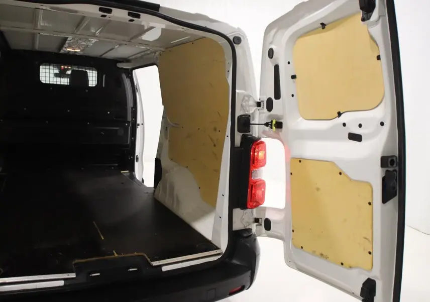 Vue arrière ouverte du fourgon blanc Citroën Jumpy XL 2019, montrant l'intérieur avec revêtement bois et plancher noir.