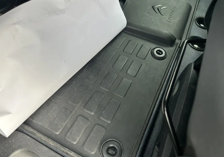 Gros plan sur le tapis de sol noir avec logo Citroën, à l'intérieur du fourgon blanc Citroën Jumpy.