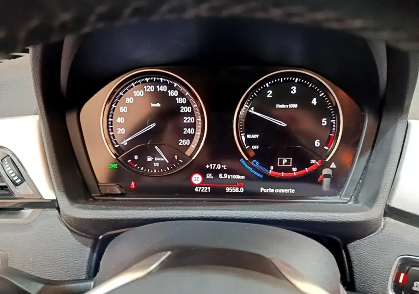 Tableau de bord numérique BMW X1 2020 sDrive16d noir, affichage vitesse, compte-tours et alertes porte ouverte.