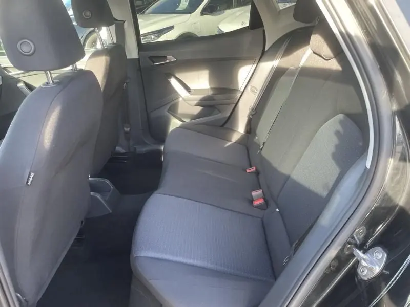 Vue intérieure côté droit sur la banquette arrière noire du SEAT Arona 1.0 TSI 95 Urban 2023, avec ceinture de sécurité visible.