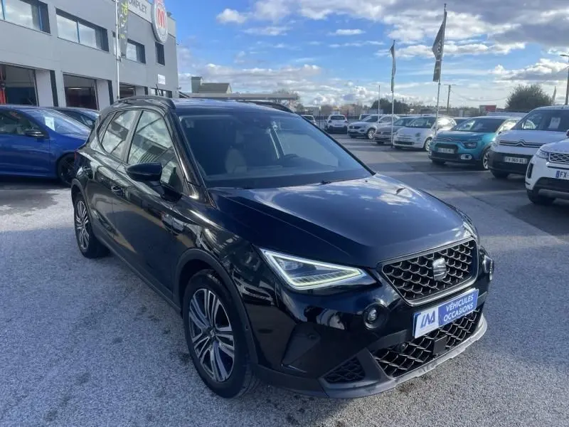 SEAT Arona noir vue 3/4 avant droit, avec calandre hexagonale et phares LED distinctifs, stationné en extérieur.
