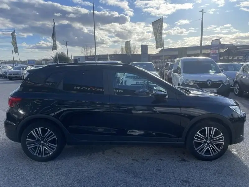 Vue de profil côté gauche d'un SEAT Arona noir 2023, version 1.0 TSI 95 URBAN avec jantes alliage distinctives.