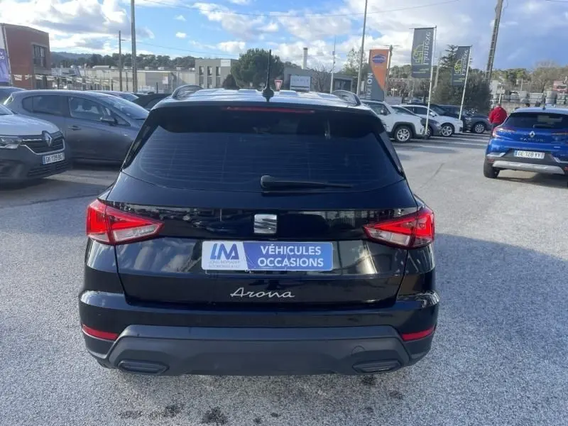 Vue arrière d’un SEAT Arona noir 2023 avec feux rouges allumés et plaque d’occasion sur parking extérieur.