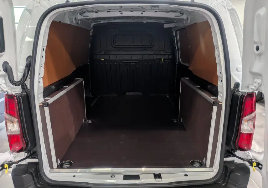 Vue arrière ouverte du Toyota Proace City Long blanc glacier, montrant l'espace de chargement vide avec parois latérales protégées.