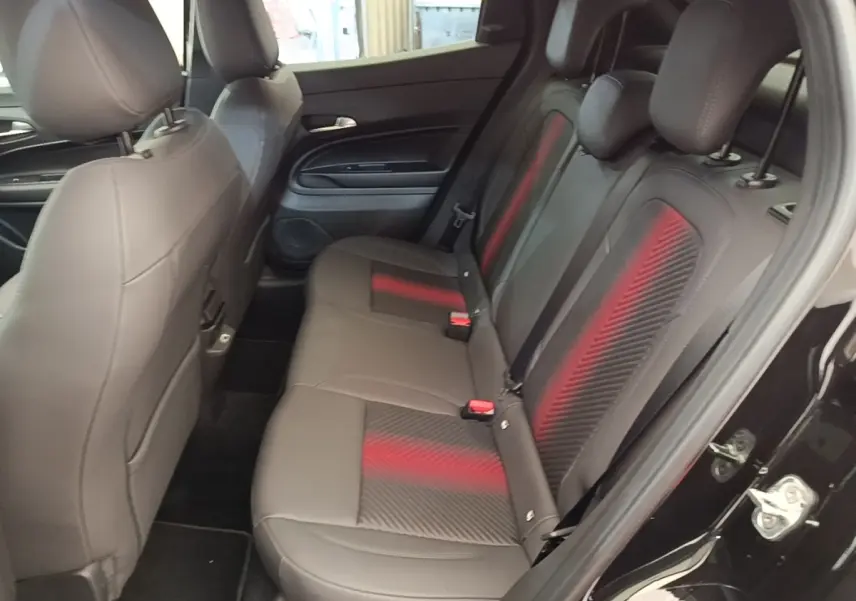 Vue côté droit des sièges arrière noirs avec inserts rouges de l'Alfa Romeo Junior 1.2 Ibrida 2024.