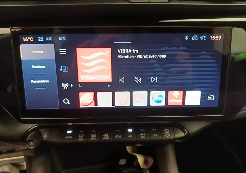 Écran tactile central de 10,25 pouces affichant la radio, dans l’habitacle noir de l’Alfa Romeo Junior 1.2 Ibrida 2024.
