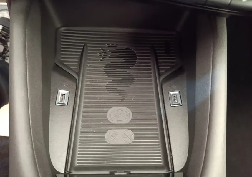 Vue rapprochée du chargeur sans fil noir avec logo Alfa Romeo et ports USB intégrés dans la console centrale.