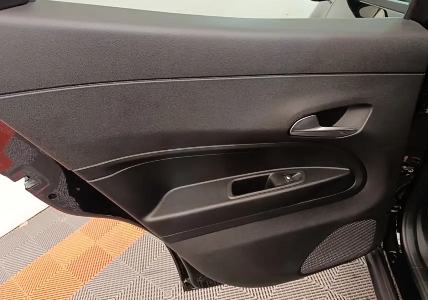 Vue intérieure de la porte arrière droite noire de l'Alfa Romeo Junior 1.2 Ibrida 2024 avec poignée et commande de fenêtre.