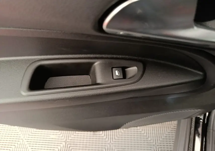 Gros plan sur la commande de lève-vitre côté gauche de la porte intérieure noire d’une Alfa Romeo Junior 2024.