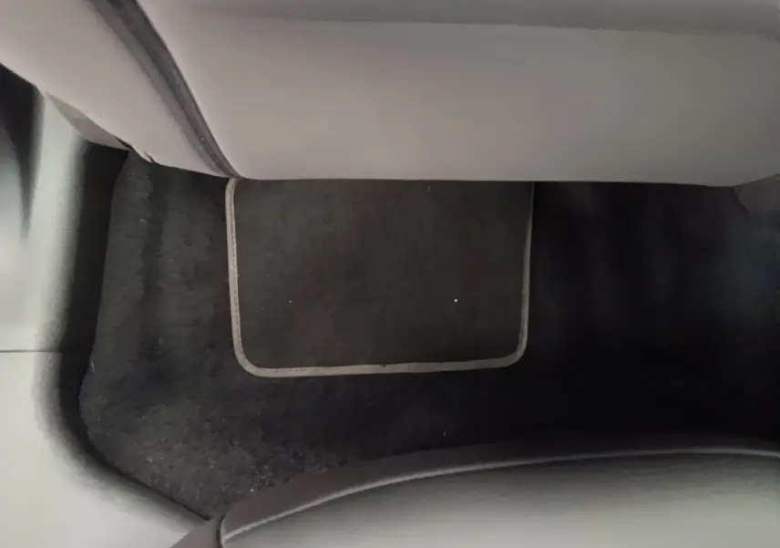 Vue intérieure du plancher avant droit avec tapis noir dans l'Alfa Romeo Junior 1.2 Ibrida 2024 noire.