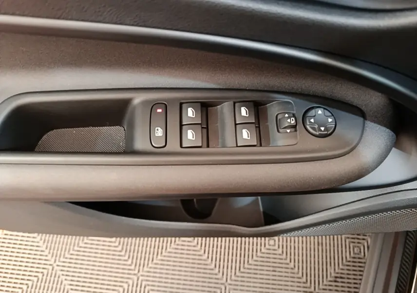 Gros plan sur la commande des vitres et rétroviseurs côté gauche de la porte d'une Alfa Romeo Junior noire.