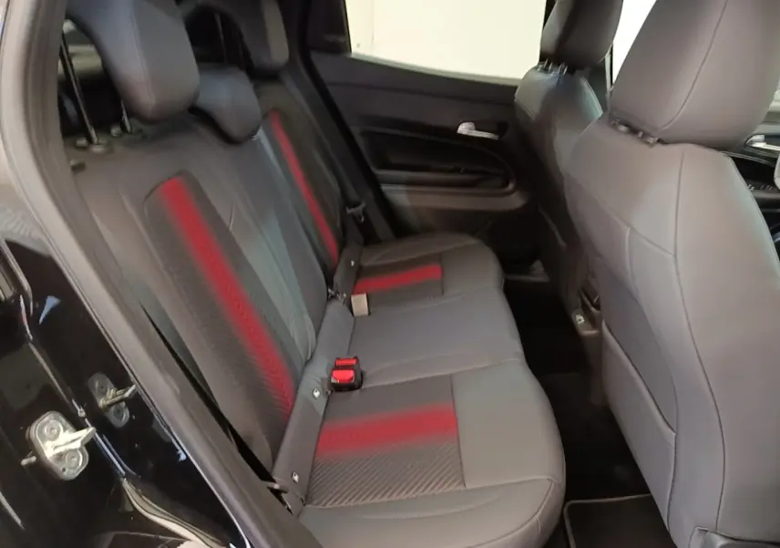 Vue intérieure côté gauche montrant la banquette arrière noire avec inserts rouges de l'Alfa Romeo Junior 2024.