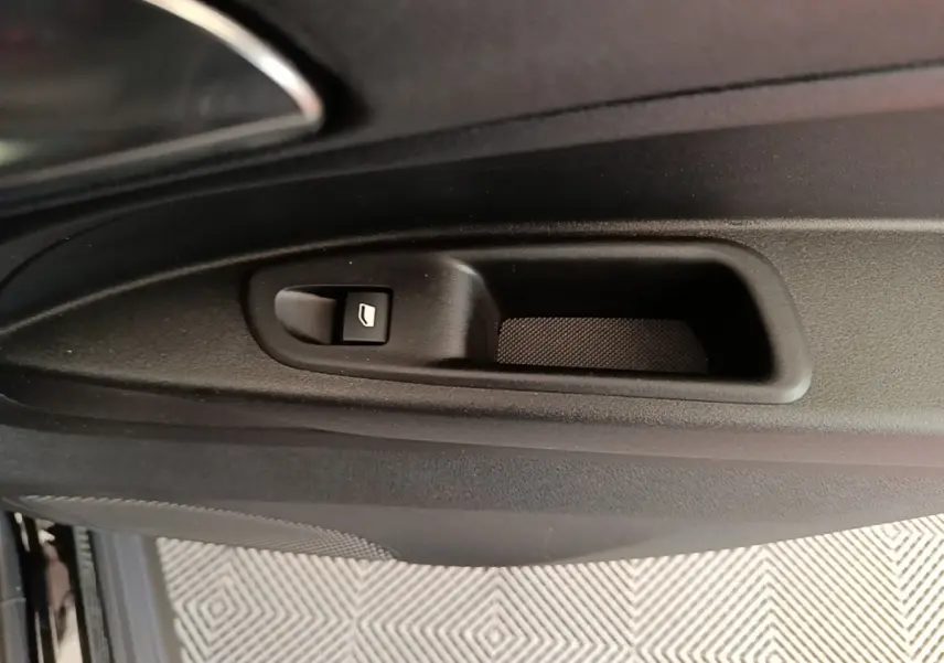 Gros plan sur la commande de lève-vitre côté intérieur d'une Alfa Romeo Junior noire, avec poignée de porte intégrée.