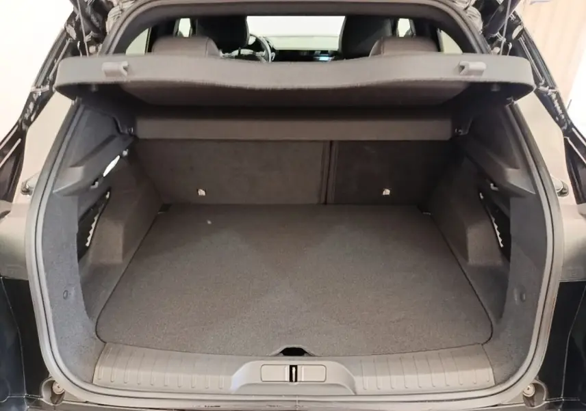 Coffre ouvert d’une Alfa Romeo Junior 1.2 hybride noire, vue arrière montrant l’espace de chargement vide.