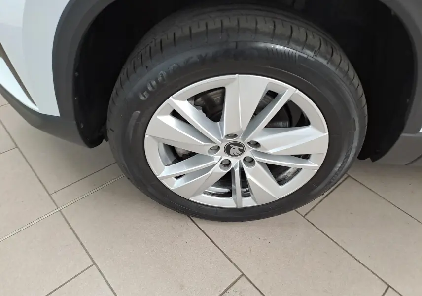 Gros plan sur la roue avant droite du Skoda Karoq blanc lune 2025 avec jante alliage et pneu Goodyear.