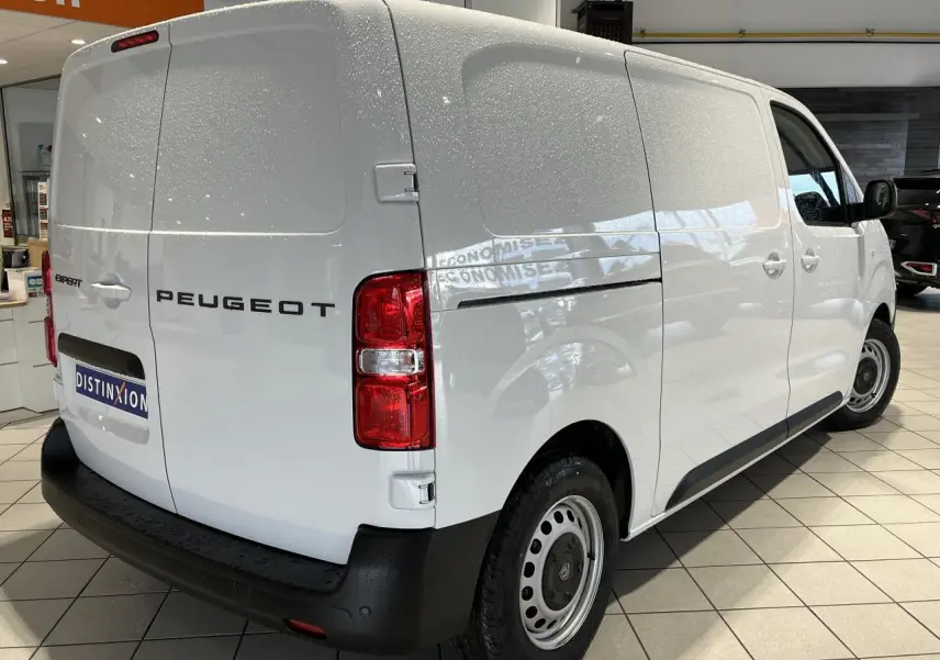 Vue 3/4 arrière droite du Peugeot Expert Fourgon blanc 2024, avec feux arrière rouges et pare-chocs noir mat.