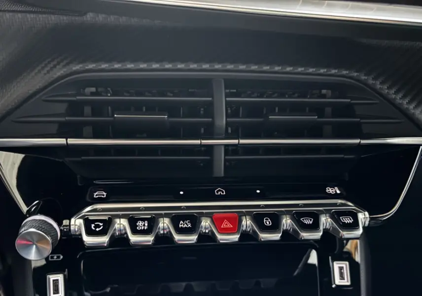 Détail du tableau de bord de la Peugeot 208 Hybrid 136 eDCS6 GT 2024 avec commandes chromées et bouton start/stop noir.