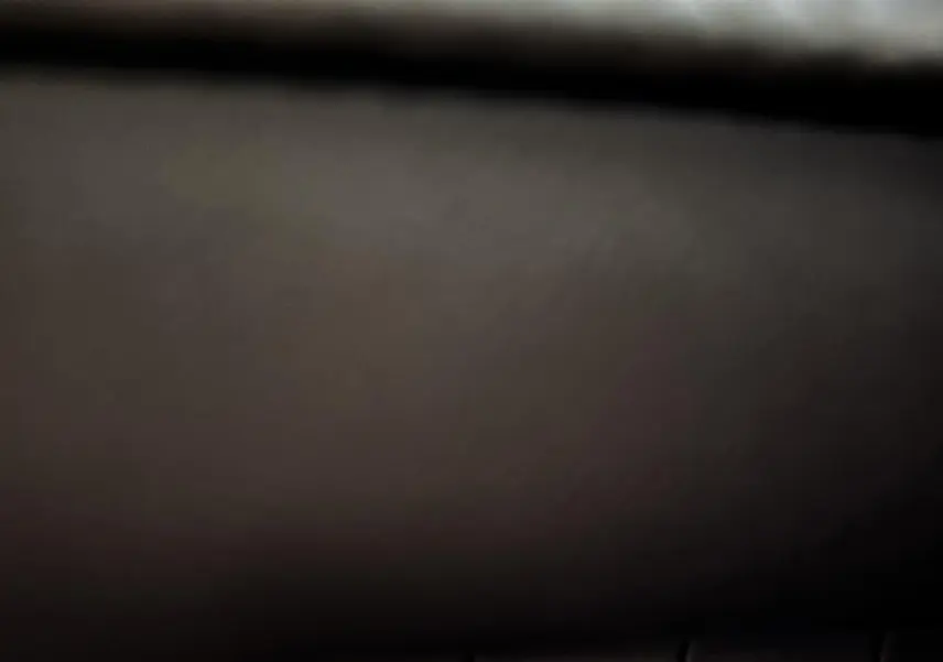 Gros plan sur le bouton d'assistance au maintien de voie dans l'habitacle sombre d'une Peugeot 208 Hybrid 136 eDCS6 GT gris foncé 2024.