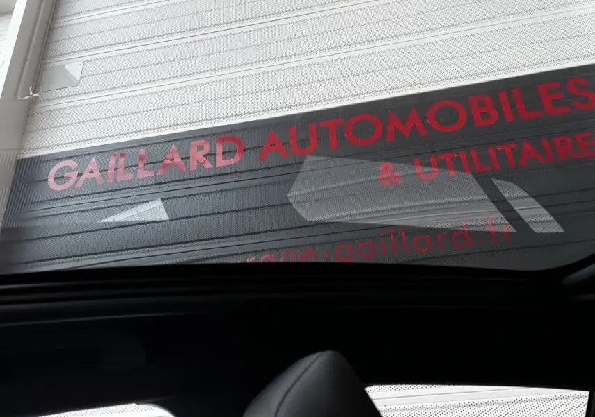 Vue intérieure arrière de la Peugeot 208 Hybrid 136 eDCS6 GT gris foncé avec toit ouvrant panoramique visible