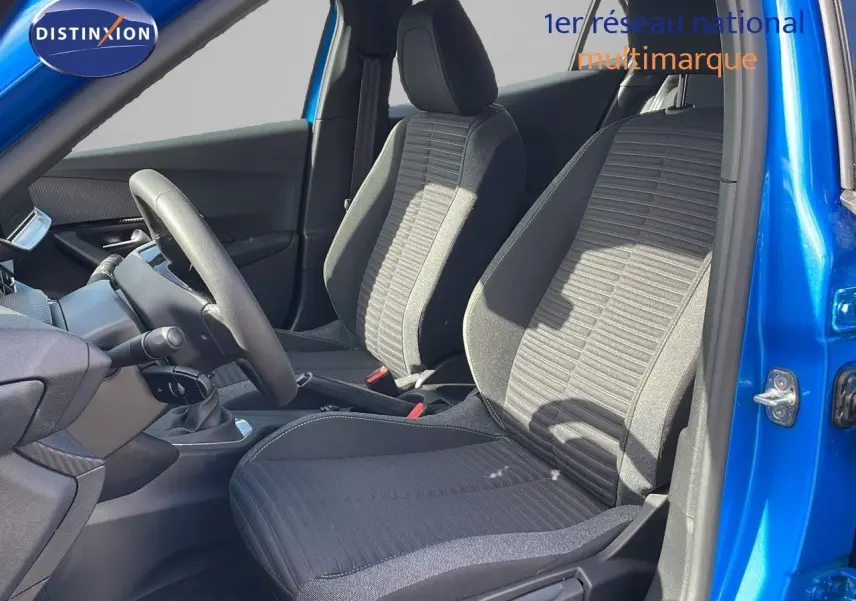 Intérieur de la Peugeot 2008 2024 en bleu Vertigo, vue côté gauche sur les sièges avant en tissu noir et gris.
